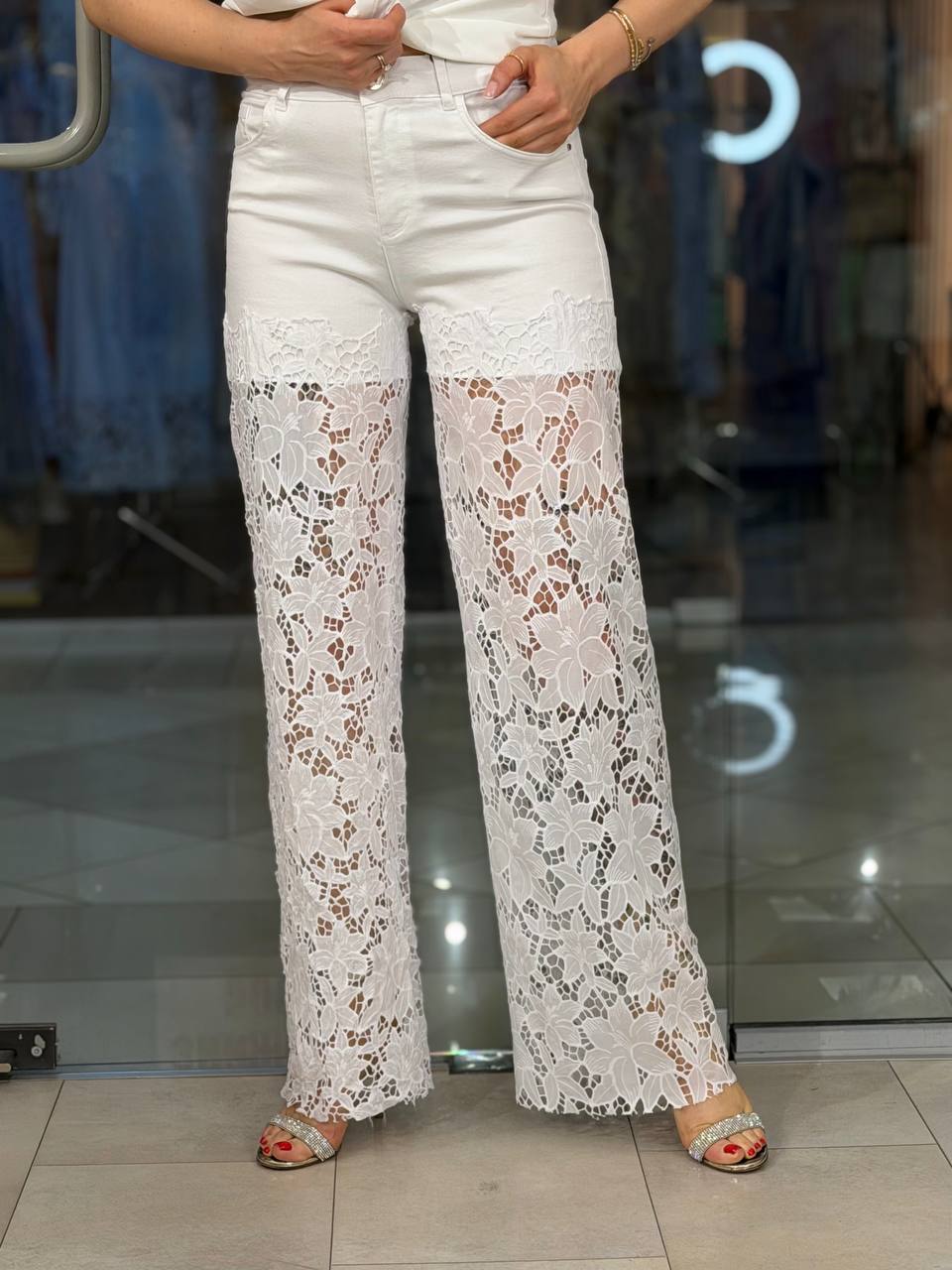Jeans blancos con flores en el bajo y cinturón de hojas.